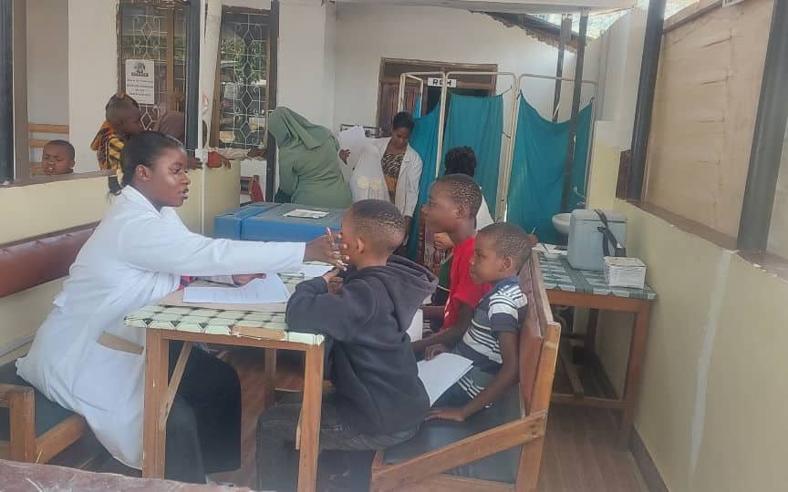Muuguzi akiwachunguza wanafunzi kwenye meza ya uchunguzi shuleni