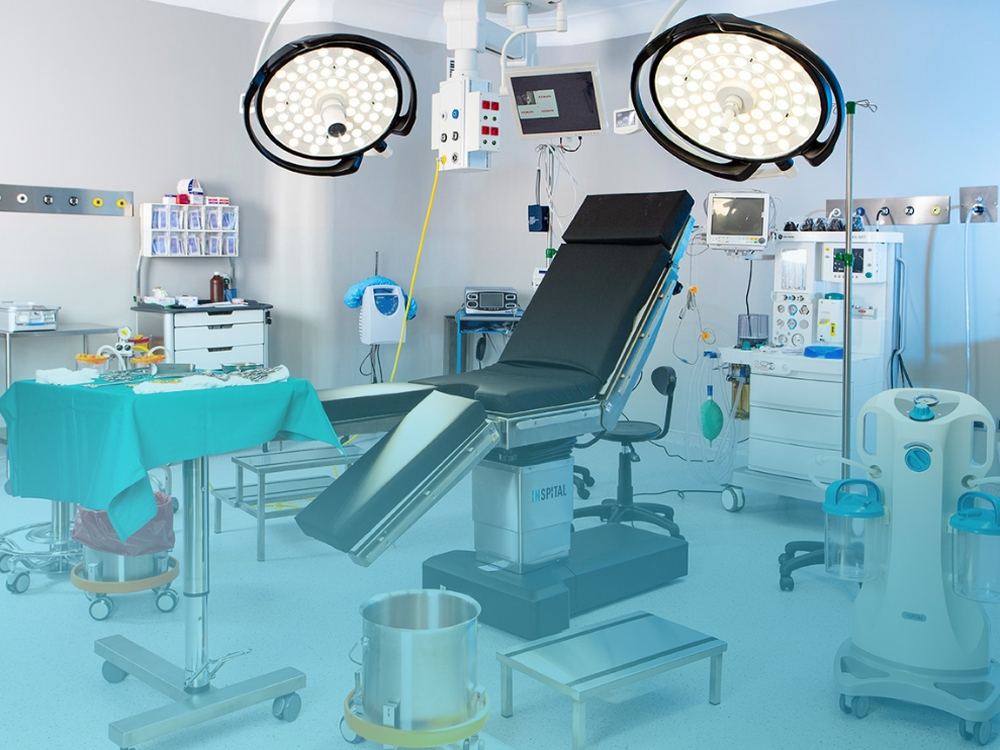 Operating theatre with surgical table, overhead lamps and anaesthesia equipment